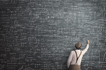 Instructor filling huge blackboard with mathematical symbols